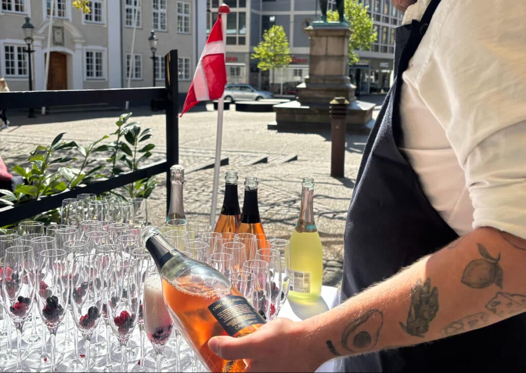 der skænkes bobler i champagne glas - restaurant rebelsk i randers